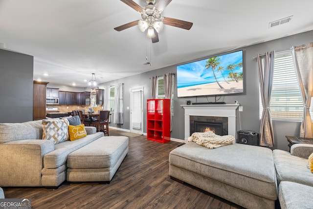 living area with recessed lighting, dark wood-style flooring, a lit fireplace, baseboards, and ceiling fan
