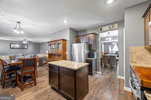548 Azalea Bloom Dr E, Loganville, GA 30052 - kitchen featuring freestanding refrigerator, dark brown cabinetry, dark wood-type flooring, and open floor plan