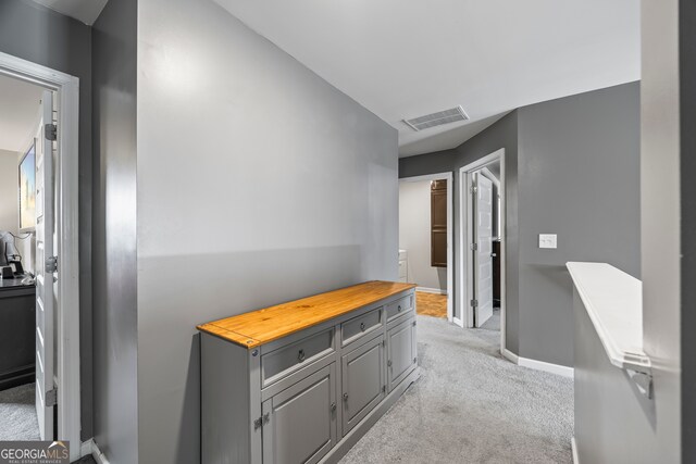 hallway with light carpet and baseboards
