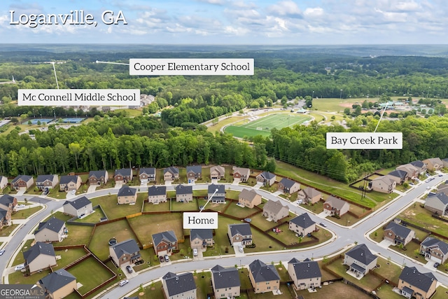 view of property location with nearby suburban area and a heavily wooded area