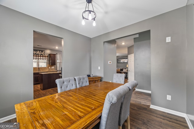 dining area with baseboards and dark wood-type flooring