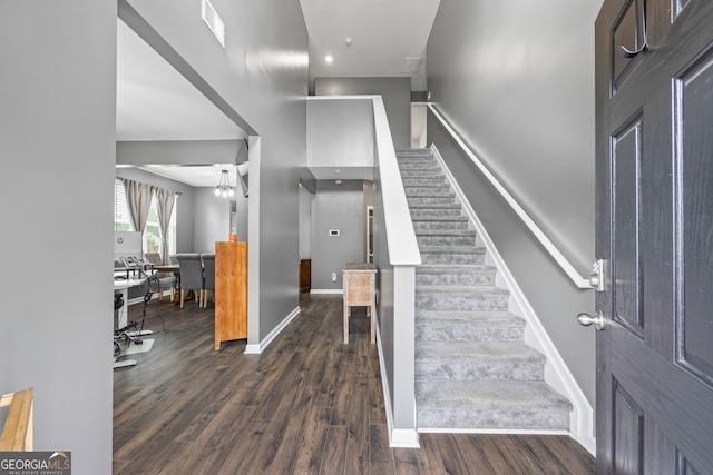 staircase featuring wood finished floors and baseboards