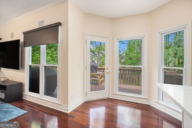 doorway to outside with hardwood / wood-style flooring, baseboards, and ornamental molding