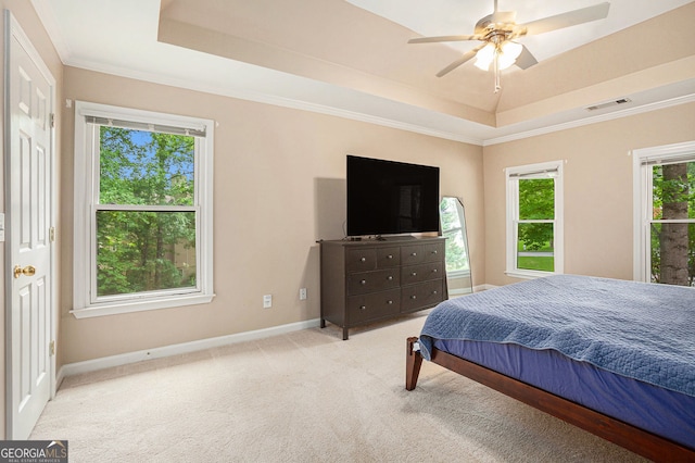 bedroom with a raised ceiling, carpet flooring, baseboards, ornamental molding, and ceiling fan