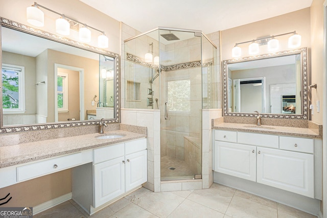full bathroom with a shower stall, tile patterned flooring, and two vanities