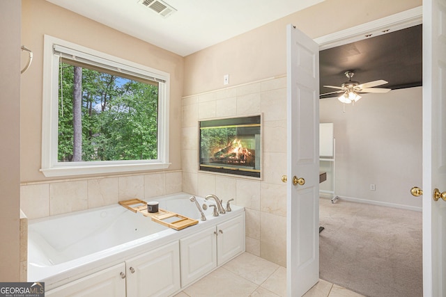 bathroom with a bath, a ceiling fan, and tile patterned flooring