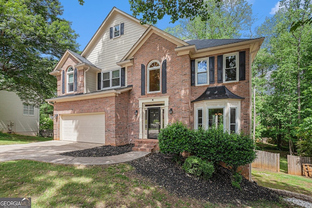 traditional-style house featuring fence, concrete driveway, an attached garage, and brick siding
