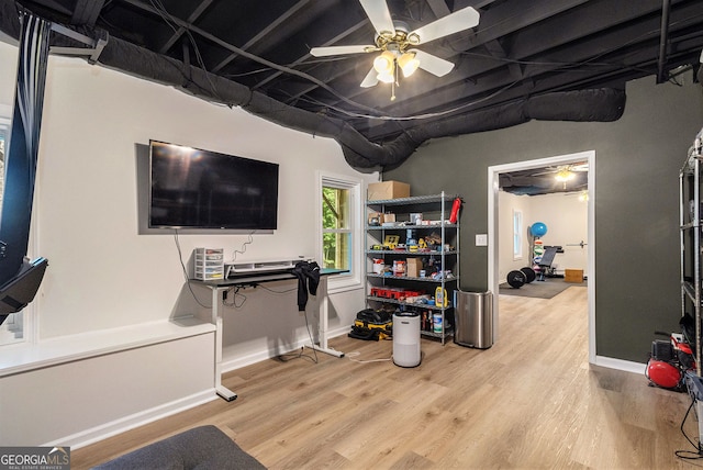 basement with wood finished floors, ceiling fan, and baseboards