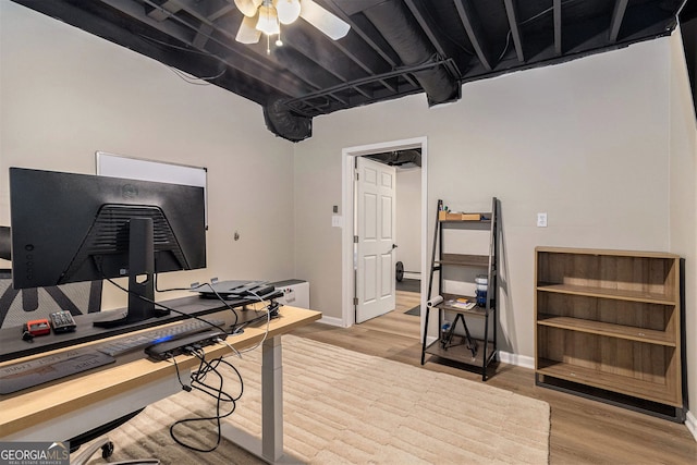 office area with a ceiling fan, wood finished floors, and baseboards