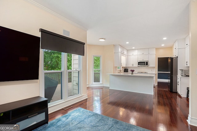 kitchen featuring appliances with stainless steel finishes, white cabinets, ornamental molding, light countertops, and dark wood-style floors