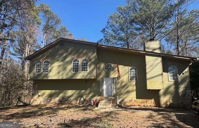 rear view of house featuring a chimney