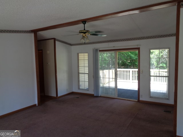 carpeted spare room featuring baseboards, a textured ceiling, and a ceiling fan