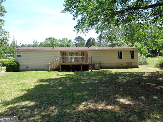 rear view of property with a lawn, crawl space, a wooden deck, and central AC