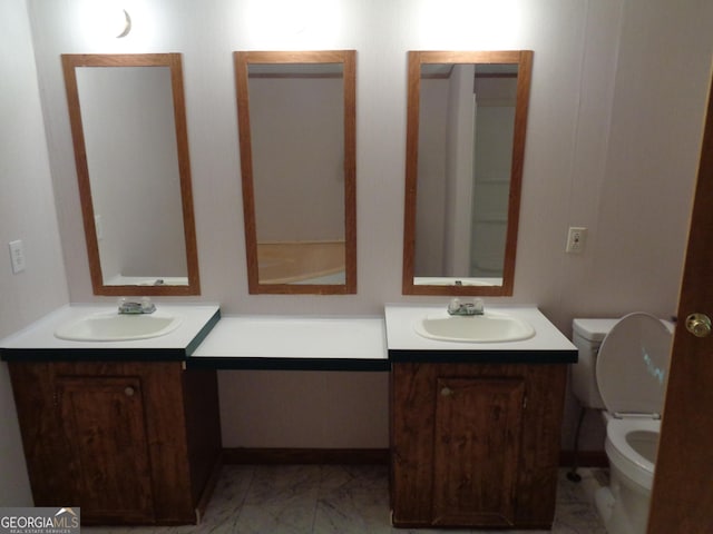 bathroom with vanity, toilet, and marble finish floor