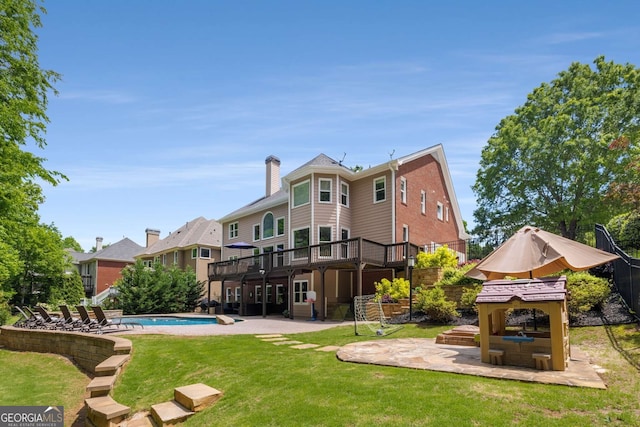 10410 High Falls Cir, Alpharetta, GA 30022 - rear view of property with a patio area, a deck, a lawn, a chimney, and an outdoor pool