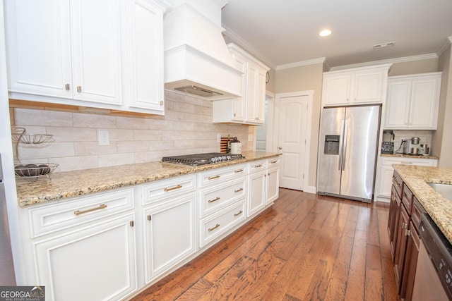 50 Brook Trl, Newnan, GA 30265 - kitchen with premium range hood, hardwood / wood-style flooring, ornamental molding, white cabinets, and appliances with stainless steel finishes