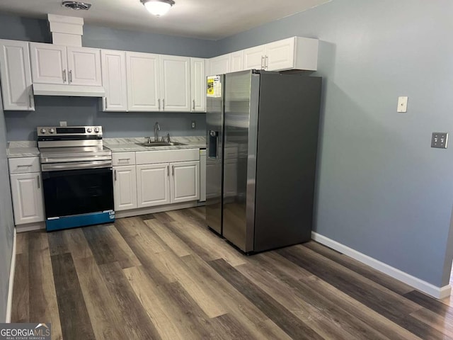 kitchen featuring a sink, stainless steel appliances, light countertops, dark wood-style floors, and baseboards