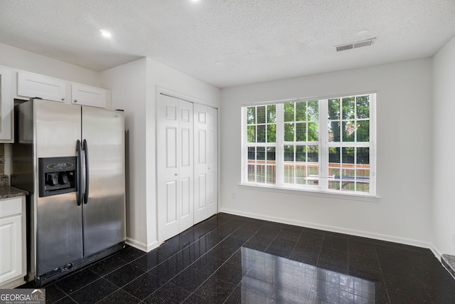 3550 Willow Tree Trce, Decatur, GA 30034 - kitchen featuring stainless steel fridge, baseboards, white cabinetry, a textured ceiling, and dark countertops