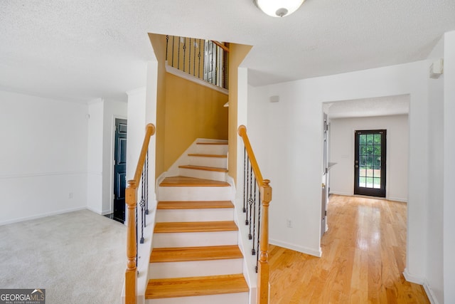 3550 Willow Tree Trce, Decatur, GA 30034 - stairs featuring a textured ceiling, wood finished floors, and baseboards