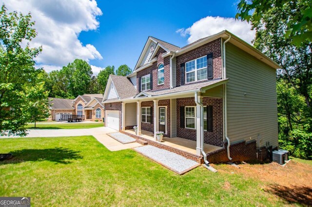 back of house featuring covered porch, brick siding, concrete driveway, and an attached garage