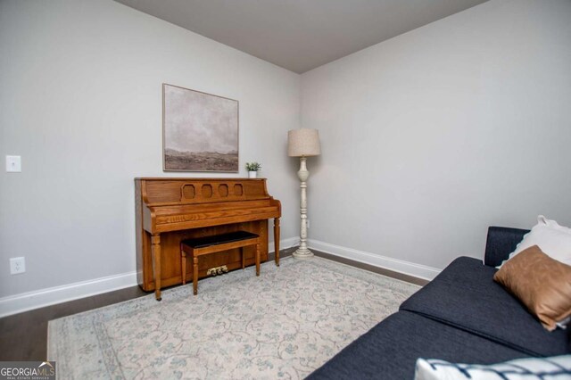 living area with baseboards and wood finished floors