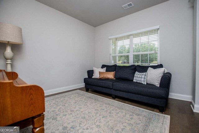 living area with baseboards and dark wood-style floors