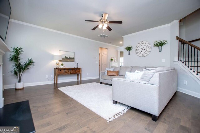 living room with a ceiling fan, stairway, crown molding, wood finished floors, and baseboards