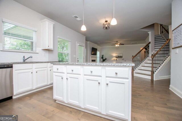 kitchen with dishwasher, a ceiling fan, white cabinets, and wood finished floors
