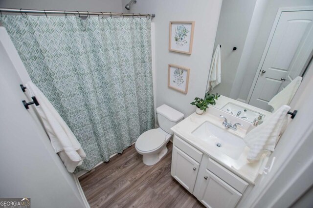 full bathroom featuring wood finished floors, toilet, vanity, and a shower with shower curtain