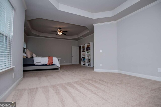 bedroom featuring a raised ceiling, baseboards, carpet, and ceiling fan