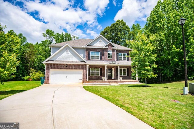 craftsman-style house with driveway, brick siding, covered porch, and a front lawn