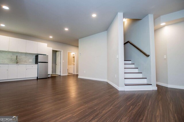 below grade area with dark wood-type flooring, baseboards, and recessed lighting