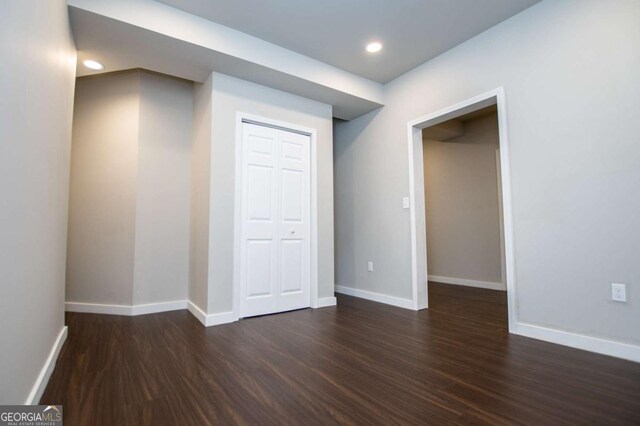 kitchen with appliances with stainless steel finishes, a wall mounted air conditioner, a sink, dark wood-style flooring, and white cabinets