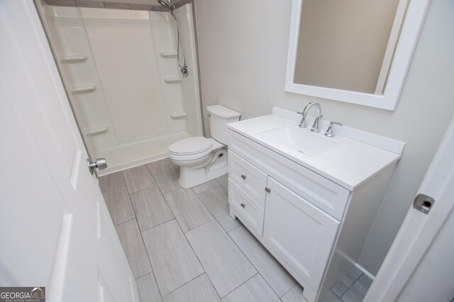 full bathroom with toilet, a shower, and vanity