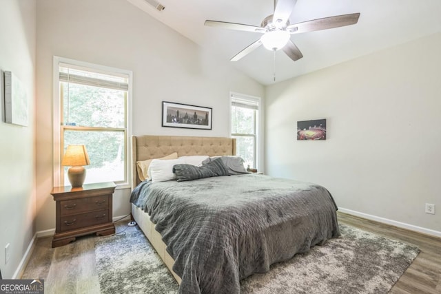 bedroom with wood finished floors, vaulted ceiling, baseboards, and a ceiling fan