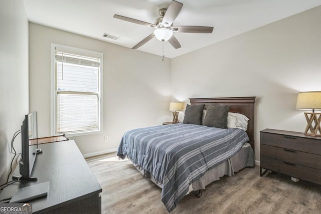 bedroom with wood finished floors, baseboards, and a ceiling fan