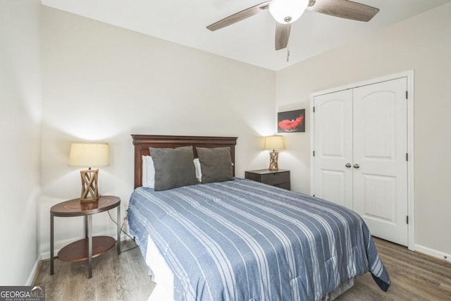 bedroom featuring wood finished floors, baseboards, a closet, and a ceiling fan