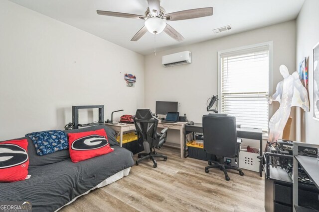 office area featuring a wall mounted air conditioner, wood finished floors, and ceiling fan