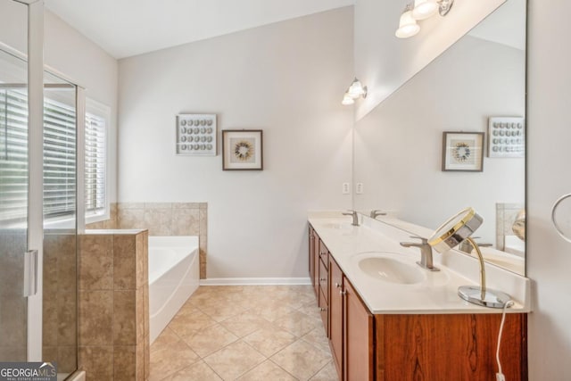 full bath with a garden tub, baseboards, tile patterned flooring, double vanity, and a stall shower