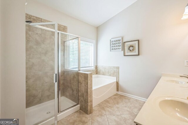 full bathroom with a bath, a shower stall, baseboards, tile patterned floors, and double vanity
