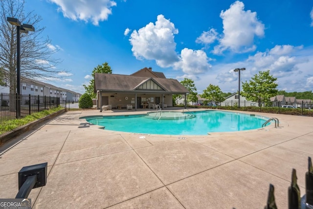 community pool featuring fence and a patio