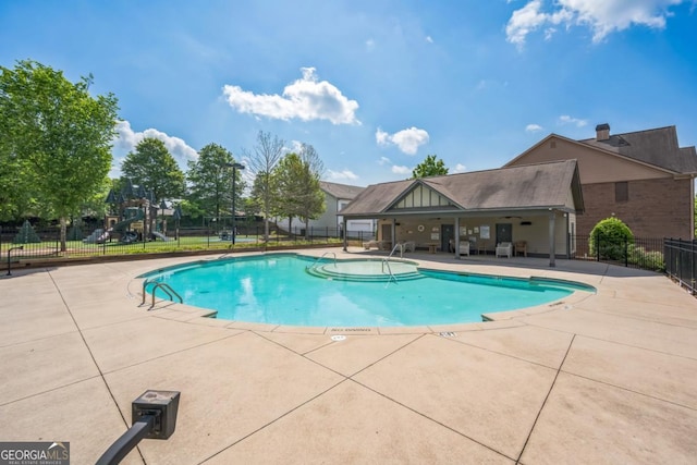 community pool featuring fence and a patio area