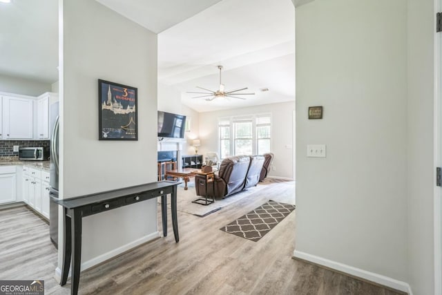 hallway with light wood finished floors and baseboards