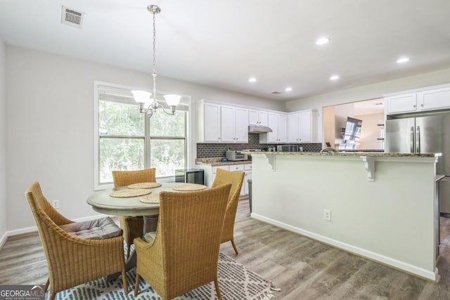 dining area with light wood-style floors, a chandelier, recessed lighting, and baseboards