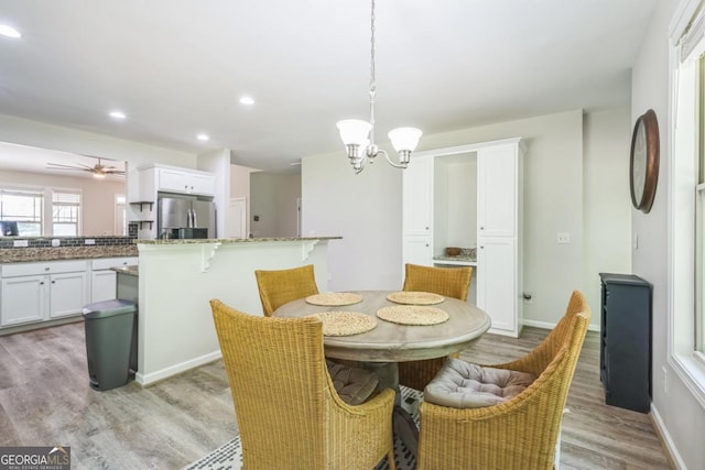 dining room featuring light wood-type flooring, a chandelier, recessed lighting, baseboards, and a ceiling fan
