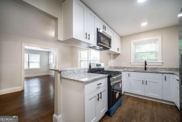 2137 Delowe Dr, Atlanta, GA 30344 - kitchen with stainless steel appliances, a sink, a peninsula, dark wood-style flooring, and white cabinets