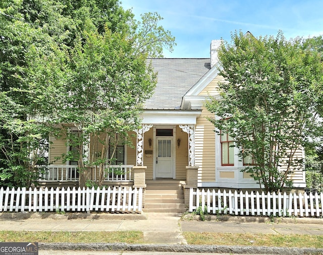 view of front facade with covered porch and a fenced front yard