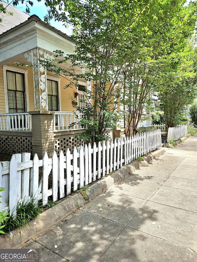 view of side of property with a porch and a fenced front yard