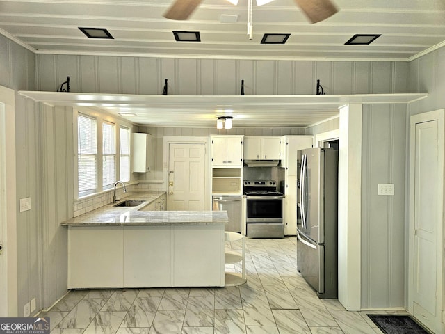 kitchen with a sink, a peninsula, marble finish floor, under cabinet range hood, and appliances with stainless steel finishes