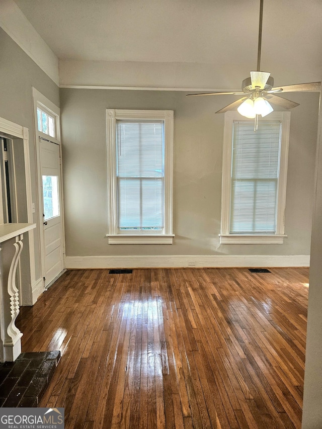 unfurnished living room with wood-type flooring, baseboards, and a ceiling fan